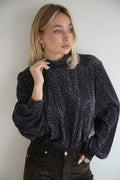 Blusa estilo romántico, micro-estampado, cuello alto perkins.