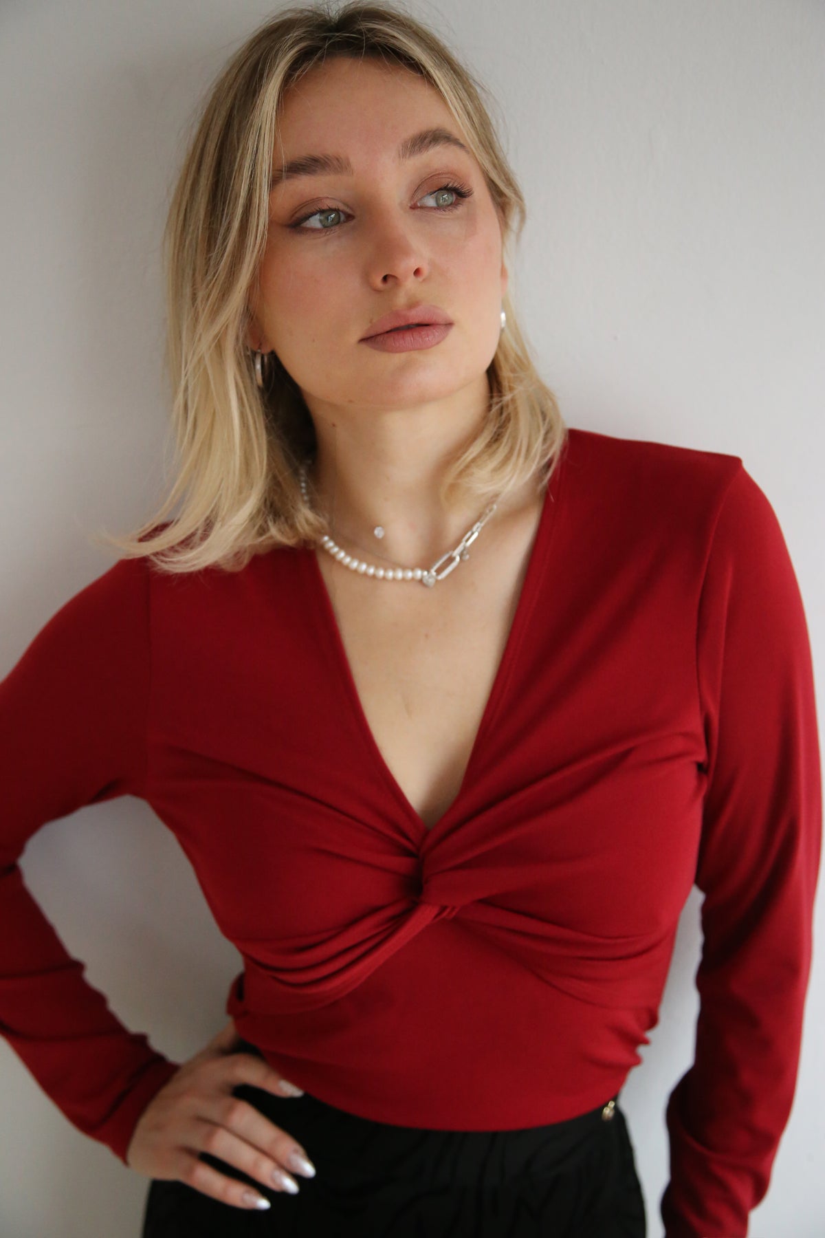Camiseta estilo minimalista, detalle de nudo frontal, escote en pico.