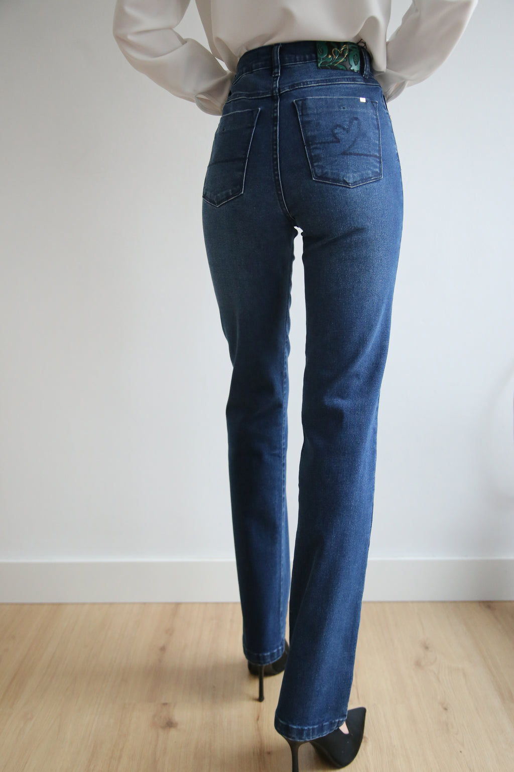Pantalón denim elástico, corte recto estilizado, tiro alto, 5 bolsillos, diseño atemporal.