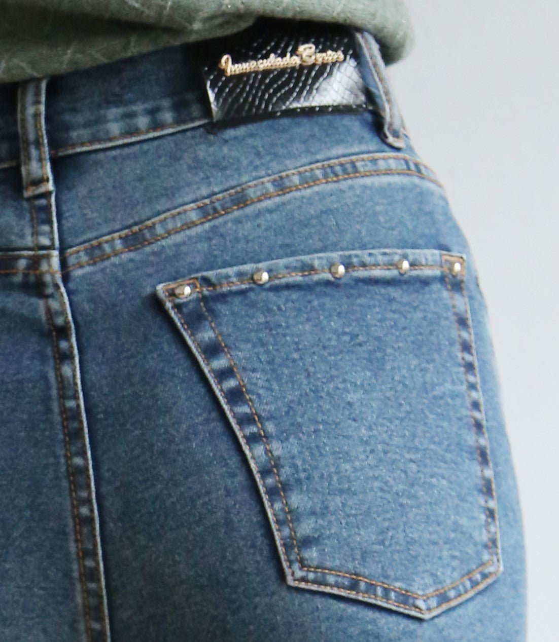Pantalón denim, tachuelas, corte flare, denim elástico.