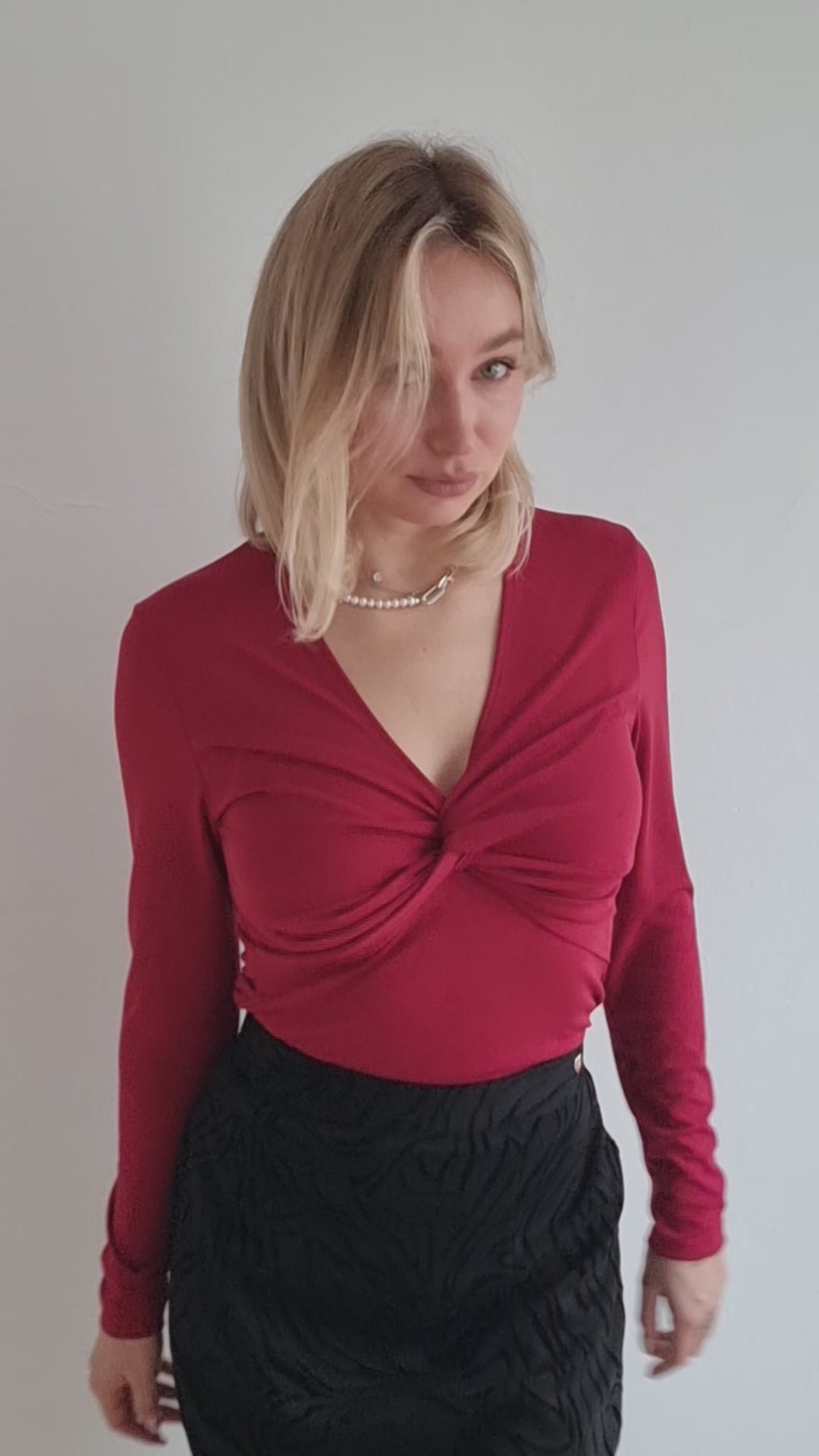 Camiseta estilo minimalista, detalle de nudo frontal, escote en pico.